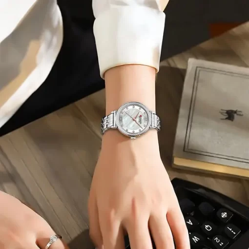 Mujer Elegante usando en su mano un Reloj Plateado para Mujer Curren 9087