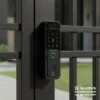 Cerradura Inteligente de Sobreponer para Rejas y Puertas Metálicas (Bluxus BC013) 14 Primer plano de la cerradura inteligente de sobreponer para rejas Bluxus BC013 con videoportero y reconocimiento facial, instalada de forma segura en una reja metálica exterior en Bogotá